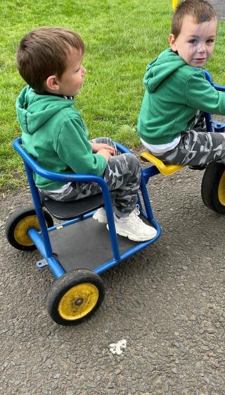 Two young boys on a tandem pedal bike