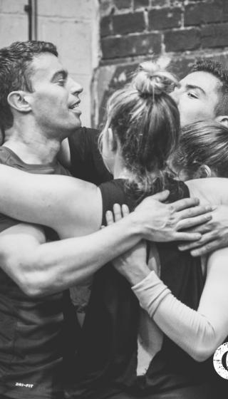 A celebratory group hug at a gym