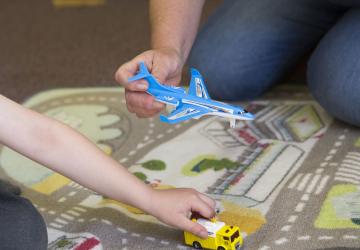 Two individuals playing with toy aeroplanes