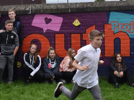 Boy running across youth centre