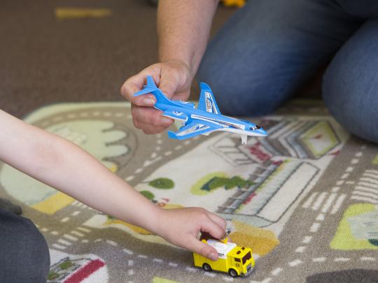 Two individuals playing with toy aeroplanes