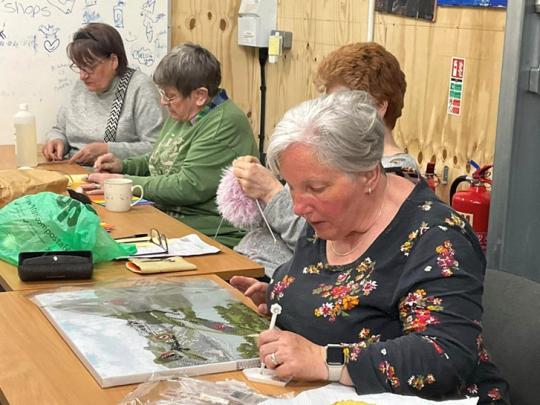 A group of women undertaking craft projects